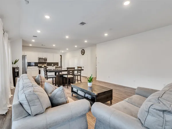 a living room with furniture kitchen area and a kitchen view