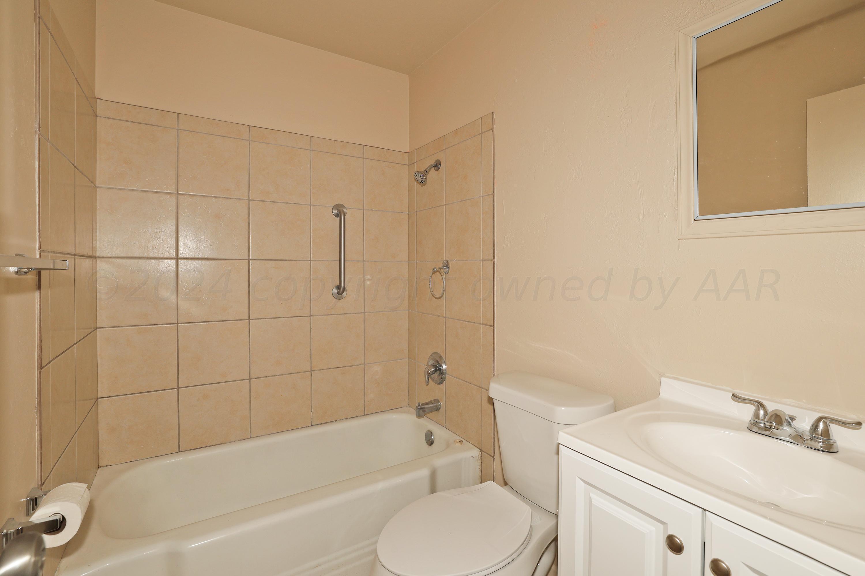 1232 Sycamore Avenue Amarillo, TX 79107 - Photo 17 of 19 a bathroom with a bathtub shower sink vanity and toilet