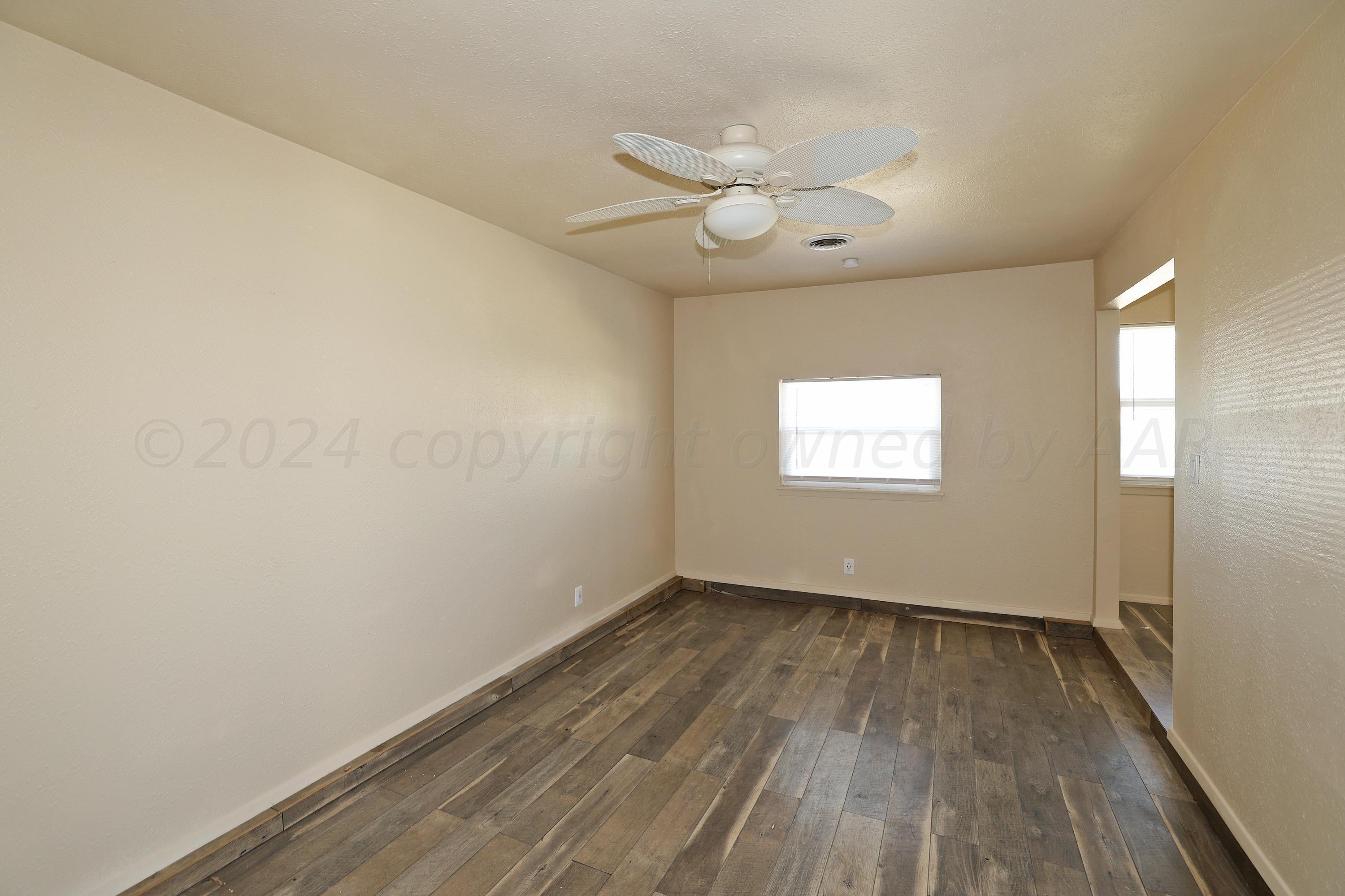 1232 Sycamore Avenue Amarillo, TX 79107 - Photo 6 of 19 a view of an empty room with wooden floor and a window