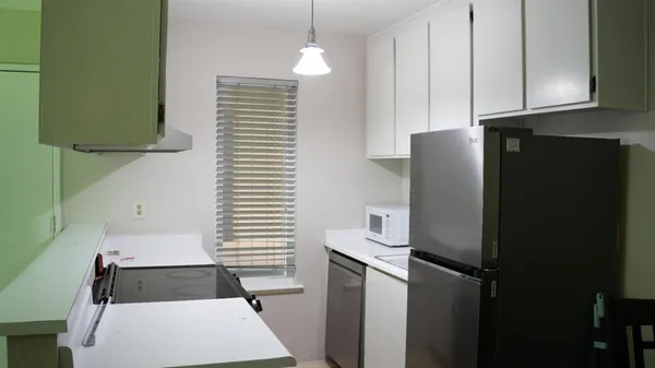 a kitchen with a refrigerator and a stove top oven
