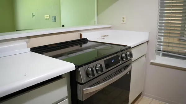 a close up of a sink a stove and a microwave