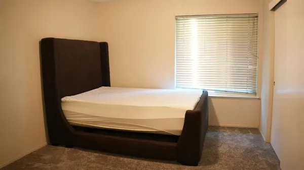 a bed sitting in a bedroom next to a window