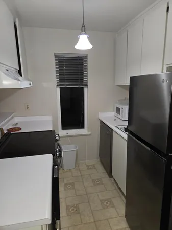 a kitchen with a refrigerator and a stove top oven