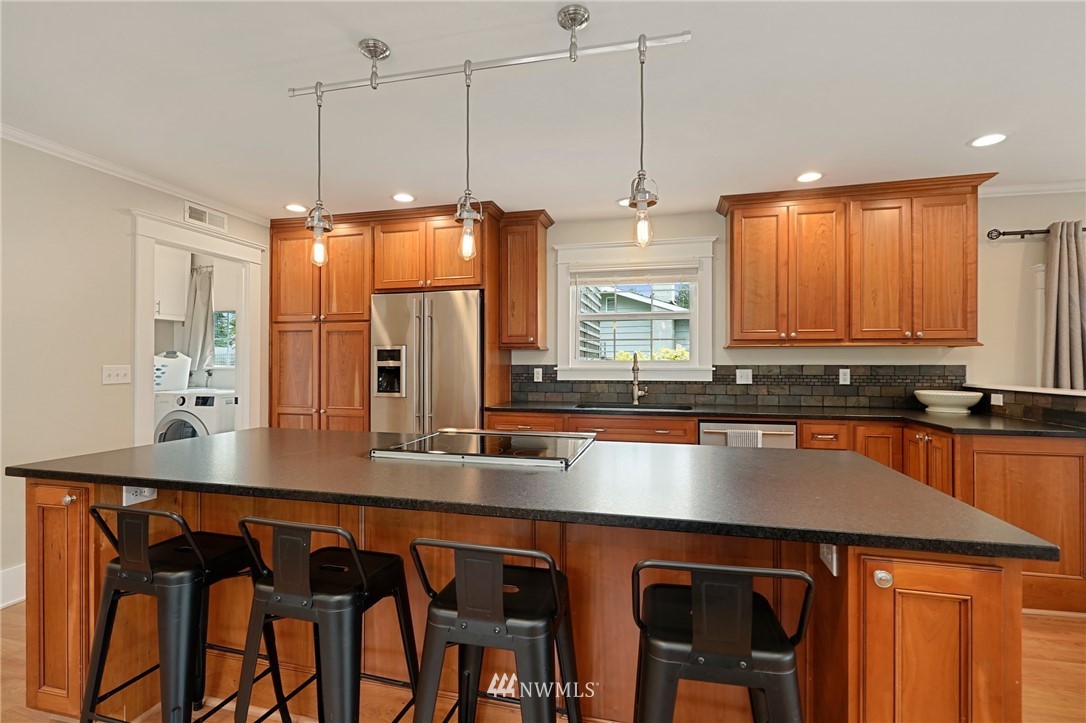 18 218th Place Southeast Bothell, WA 98021 - Photo 9 of 34 a kitchen with stainless steel appliances granite countertop a table chairs in it and wooden floors
