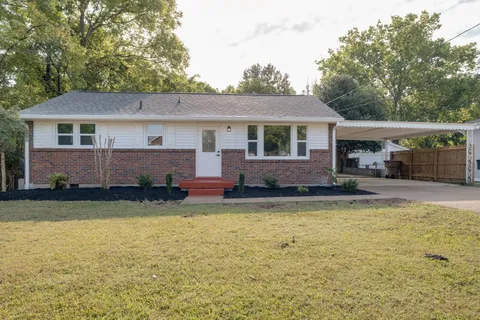a view of a house with a yard and garage