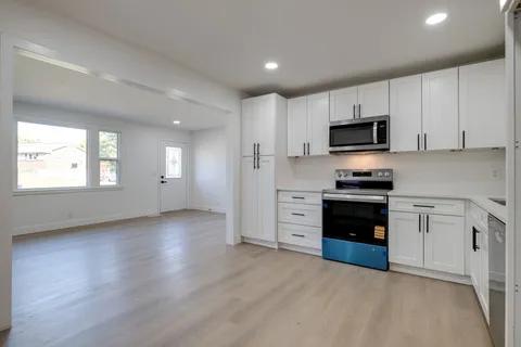 a kitchen with stainless steel appliances a stove sink microwave and cabinets