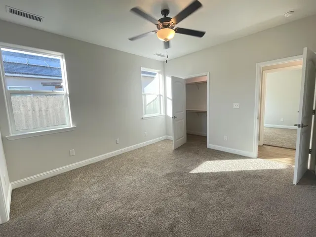 an empty room with fan and windows
