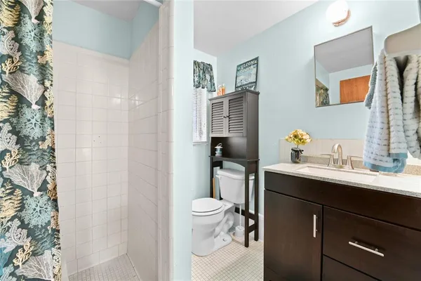 a bathroom with a sink toilet vanity and shower