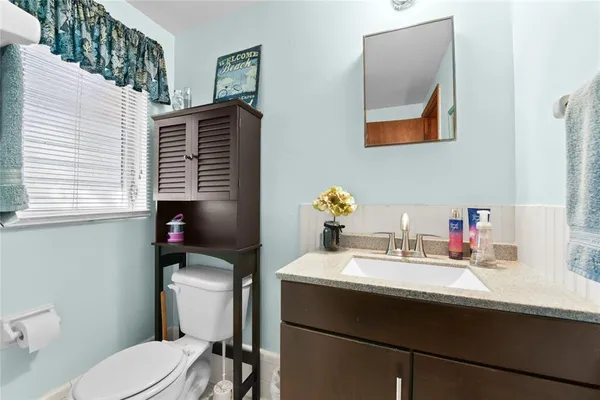 a bathroom with a sink toilet and mirror