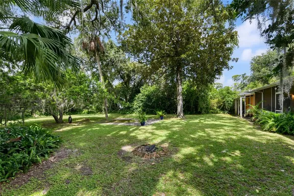 a yard with a house and trees in the background