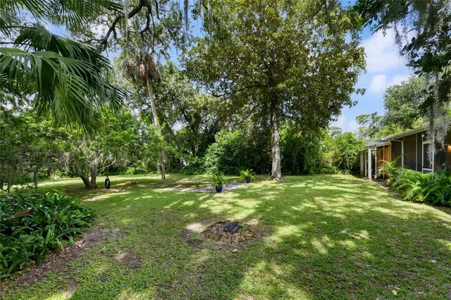 a yard with a house and trees in the background