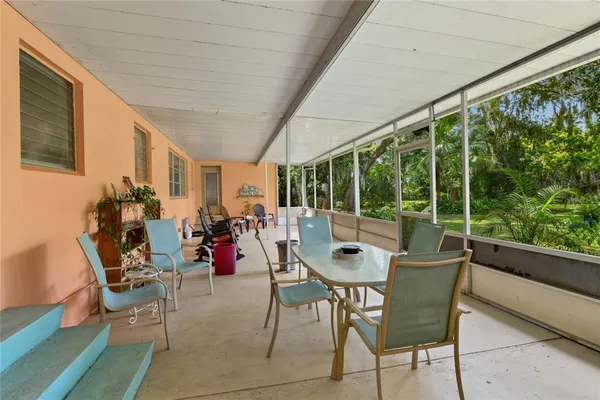 a dining room with furniture water view and a floor to ceiling window