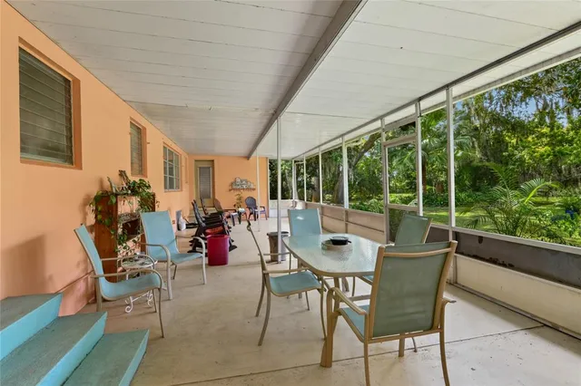 a dining room with furniture water view and a floor to ceiling window