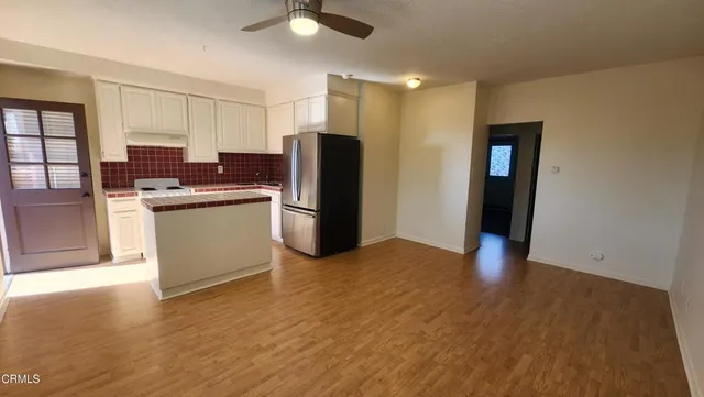 a kitchen with stainless steel appliances granite countertop a refrigerator and a stove top oven