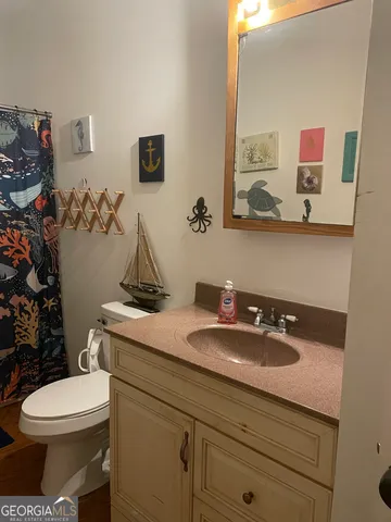 a bathroom with a toilet sink and mirror