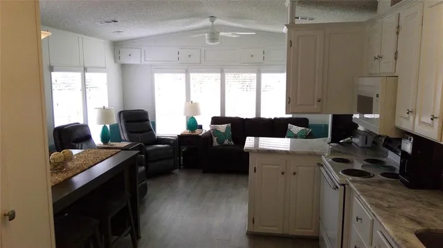 a kitchen with a sink dishwasher a stove a refrigerator and a dining table with wooden floor