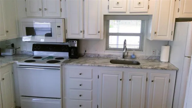 a kitchen with granite countertop cabinets stainless steel appliances and a sink