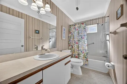 a bathroom with a sink a toilet a mirror and shower