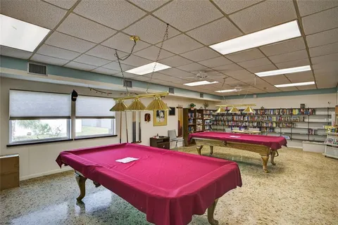 a view of a room with pool table and windows