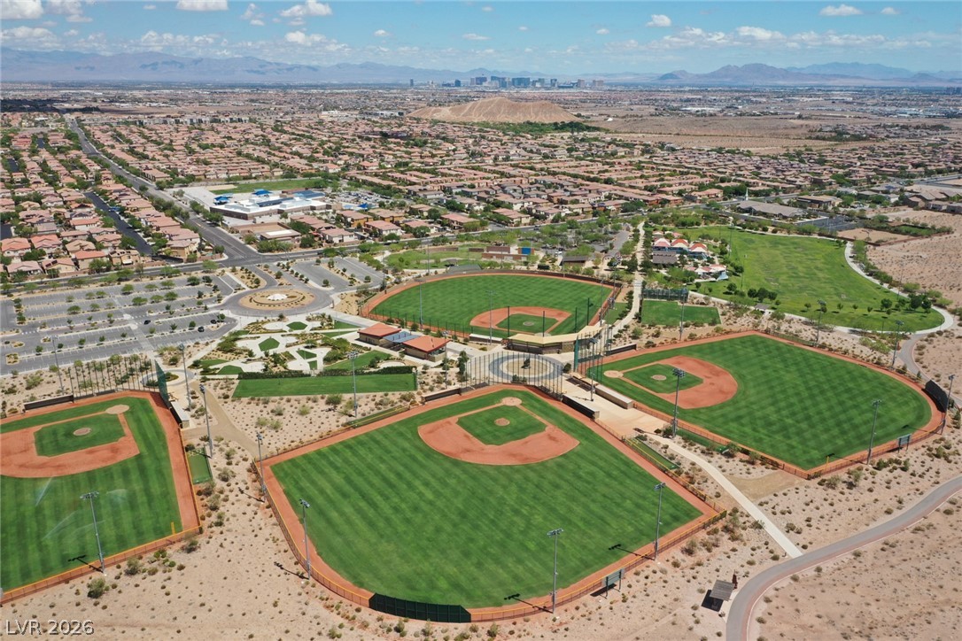 9916 Sable Point Street Las Vegas, NV 89178 - Photo 73 of 73 An aerial perspective reveals a vibrant community with multiple baseball diamonds and a sweeping desert landscape.