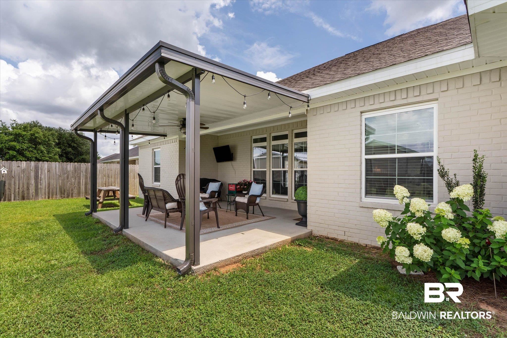 9074 Moses Way Theodore, AL 36582 - Photo 41 of 52 Expansive covered patio featuring string lights, a ceiling fan, and a concrete slab
