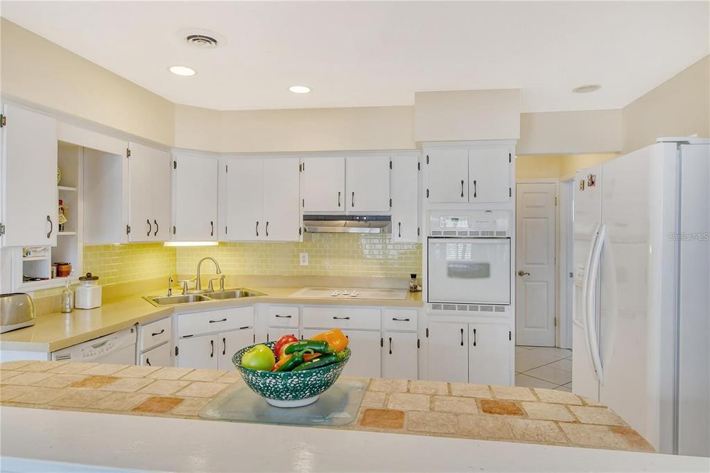449 Redwood Road Venice, FL 34293 - Photo 11 of 40 a large kitchen with stainless steel appliances kitchen island granite countertop a refrigerator and a sink