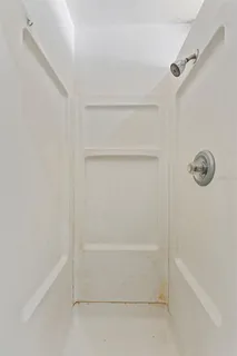 a view of an empty room with window and cabinet