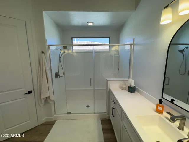 a bathroom with a tub sink shower and mirror