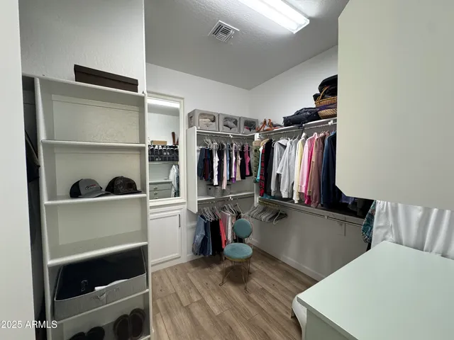 a view of walk in closet with clothes and shoes