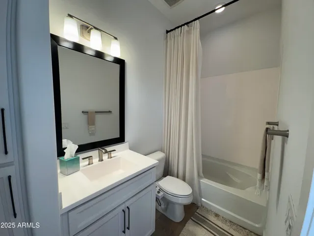 a bathroom with a granite countertop sink toilet and shower