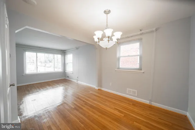 a view of empty room with wooden floor and window