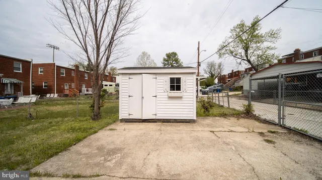 a view of a white house with a large tree