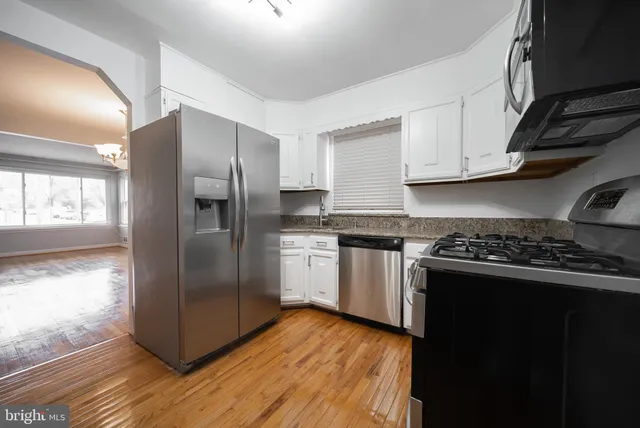 a kitchen with a refrigerator sink and cabinets