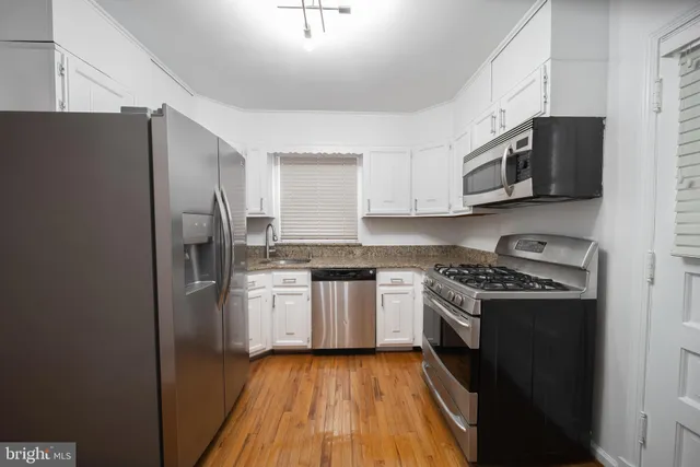 a kitchen with stainless steel appliances granite countertop a stove a refrigerator and a microwave
