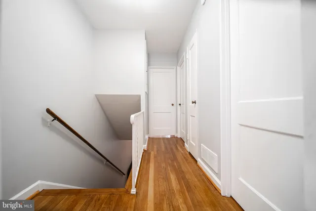 a view of a hallway with wooden floor and staircase