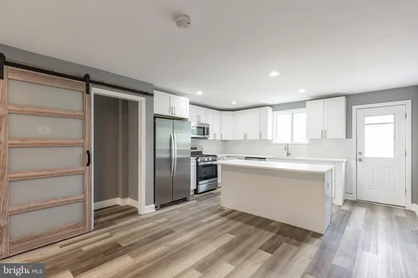 a kitchen with a refrigerator and white cabinets