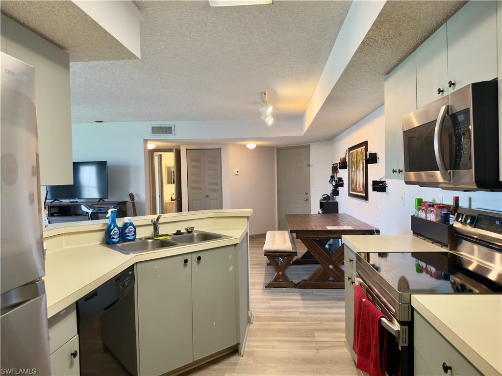 13615 Eagle Ridge Drive, Unit 1614 Fort Myers, FL 33912 - Photo 26 of 34 Spacious interior featuring large format tile flooring and a vaulted ceiling