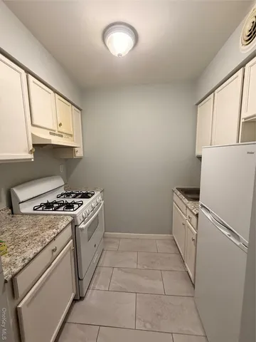 a kitchen with a stove top oven a sink and a window