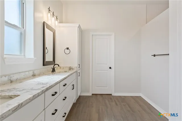 a spacious bathroom with a granite countertop sink and a mirror
