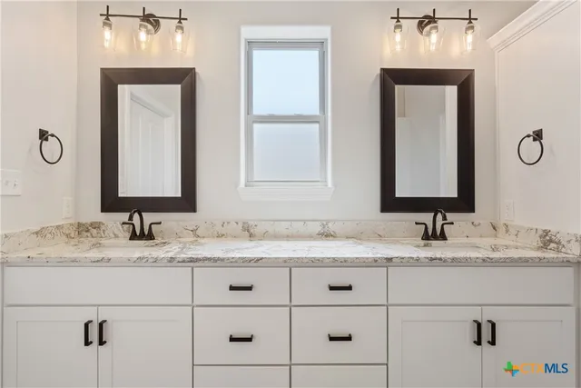 a bathroom with a granite countertop sink vanity and mirror