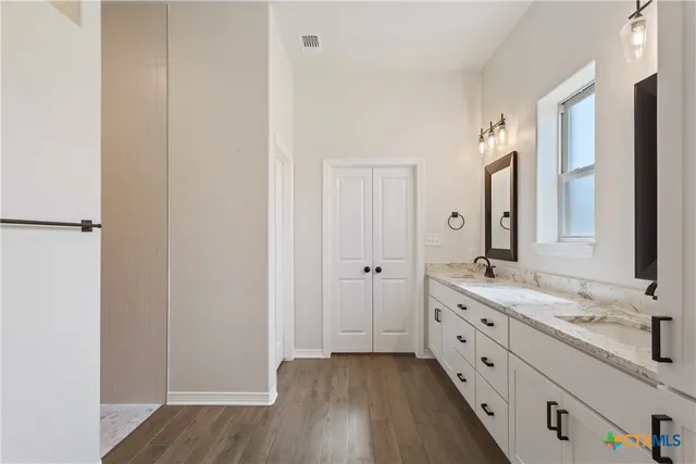 a bathroom with a granite countertop sink and a mirror