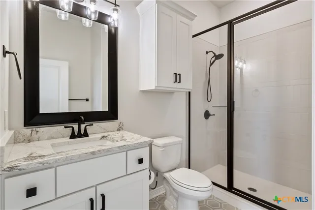 a bathroom with a granite countertop sink toilet and shower