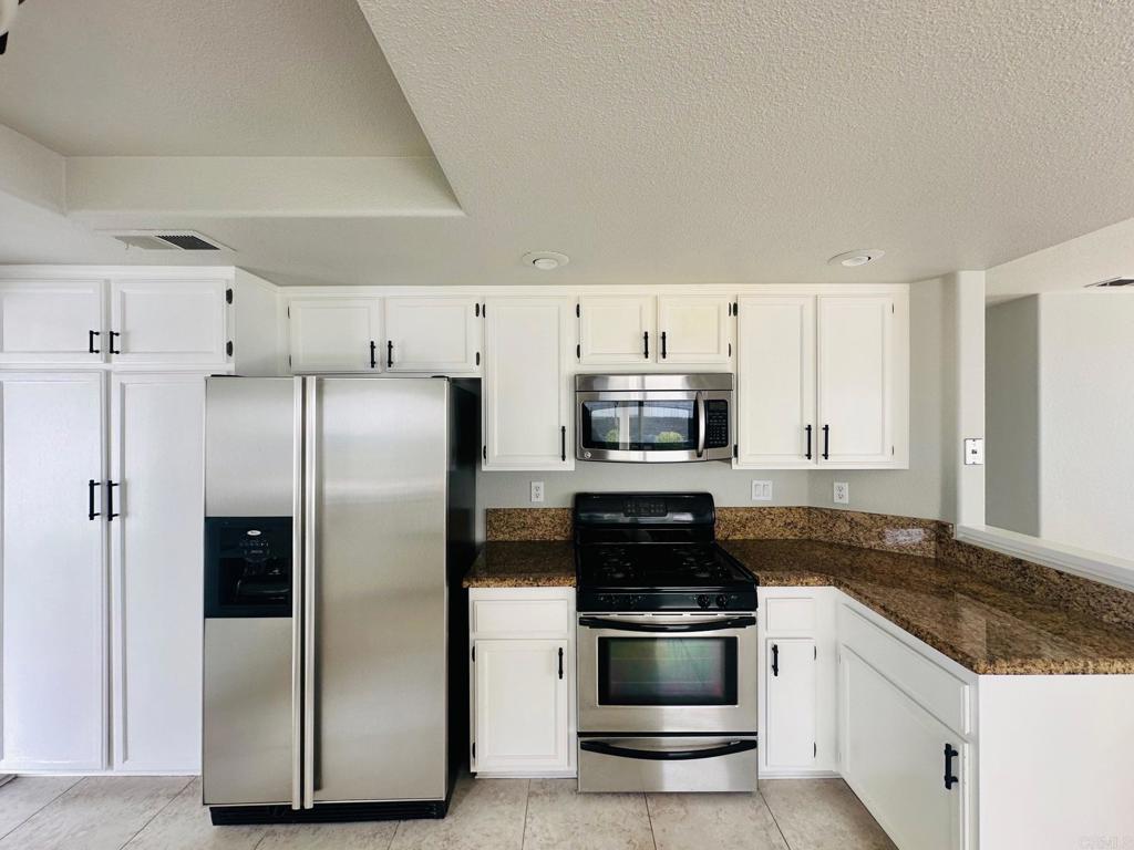 652 Montage Road Oceanside, CA 92057 - Photo 5 of 15 a kitchen with stainless steel appliances a refrigerator sink and microwave