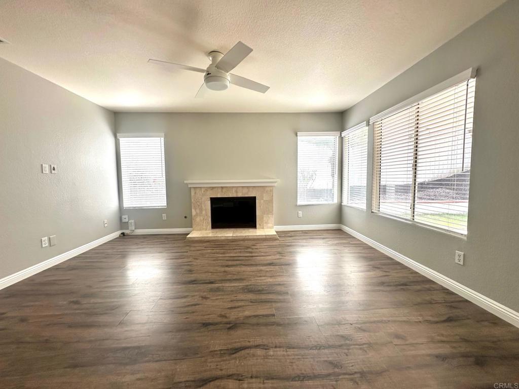 652 Montage Road Oceanside, CA 92057 - Photo 6 of 15 an empty room with wooden floor fireplace and windows