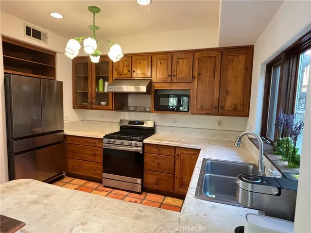 a kitchen with a sink stainless steel appliances and cabinets
