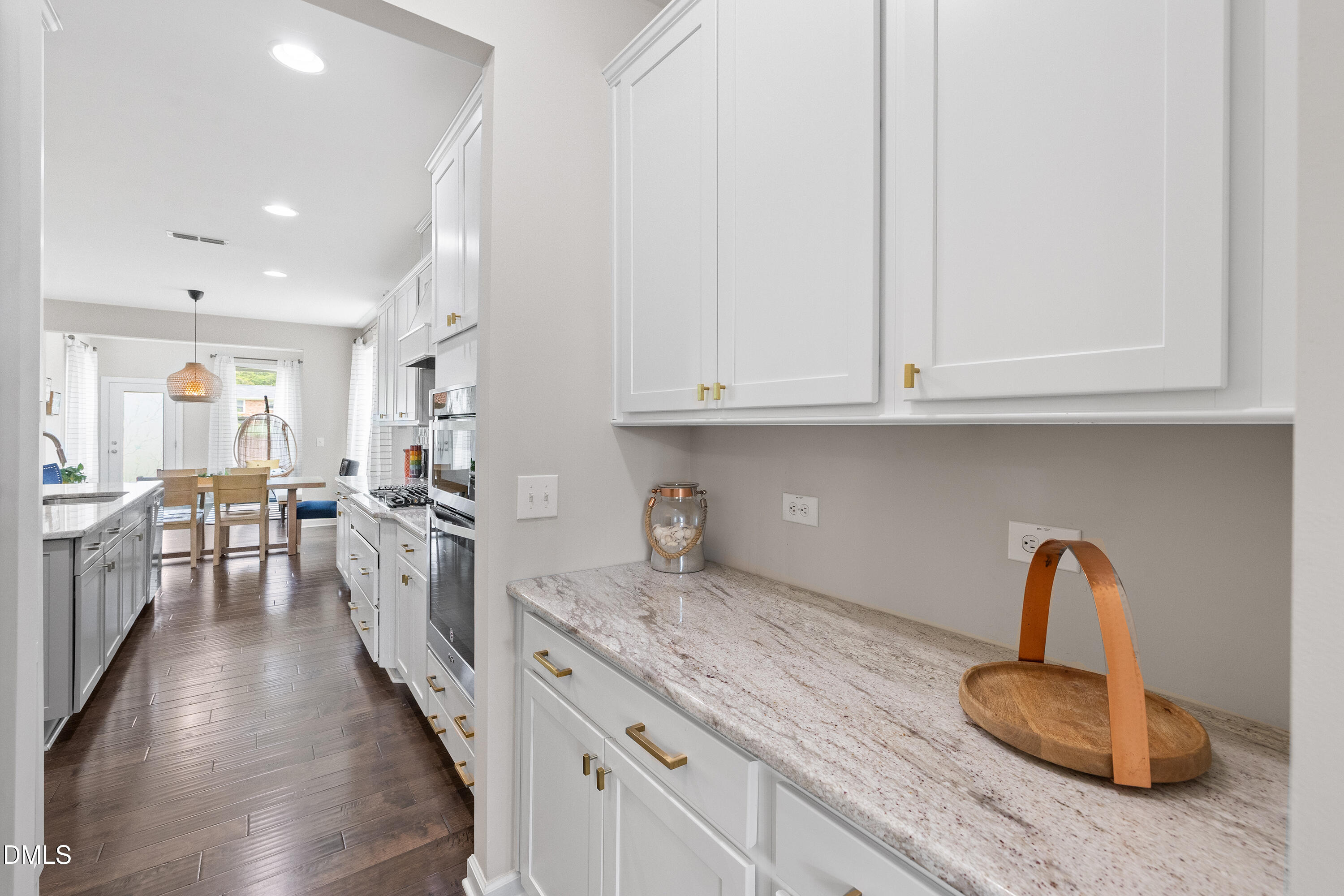8059 Gilano Drive Raleigh, NC 27603 - Photo 13 of 43 a kitchen with granite countertop a stove a sink dishwasher and white cabinets with wooden floor