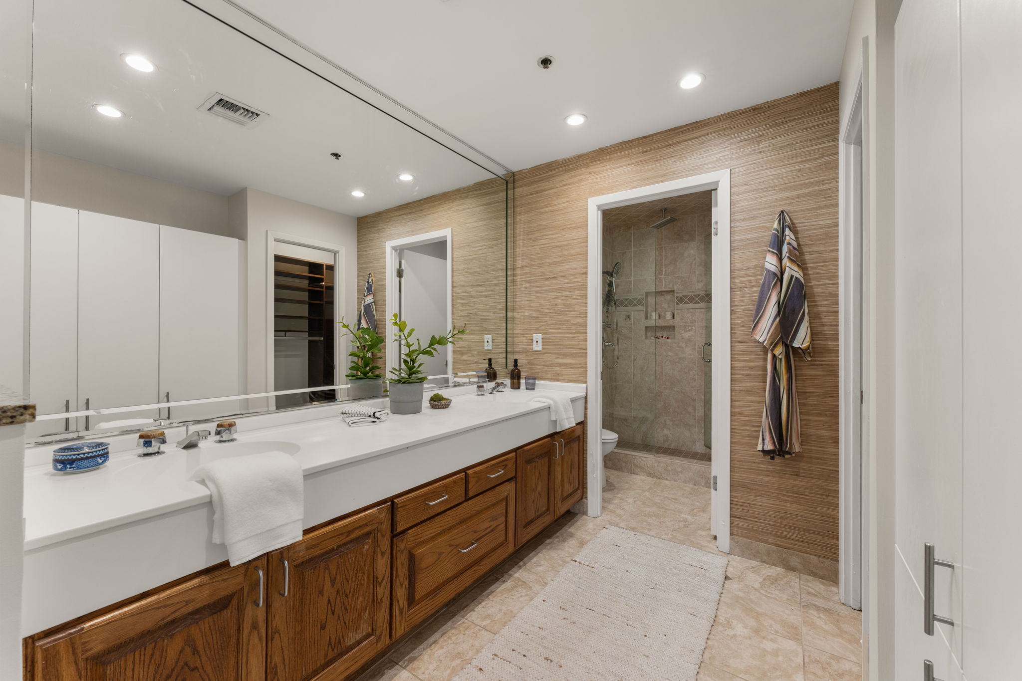 40 North Interstate Highway 35, Unit 11B2 Austin, TX 78701 - Photo 14 of 28 A well-appointed bathroom features a spacious vanity with dual sinks, leading to a glass-enclosed shower.