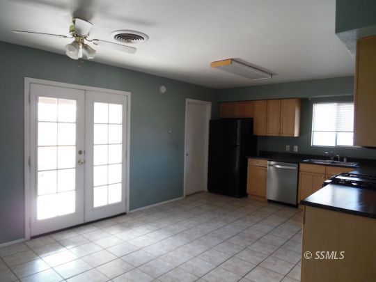 1612 South Yorktown Street Ridgecrest, CA 93555 - Photo 7 of 26 a kitchen with a refrigerator a sink and dishwasher with a large window