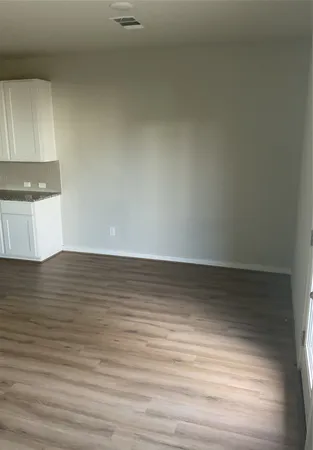 a view of an empty room and wooden floor