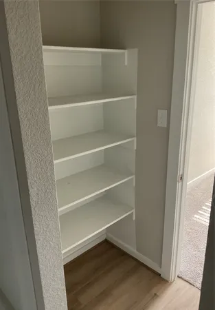a view of walk in closet with empty racks